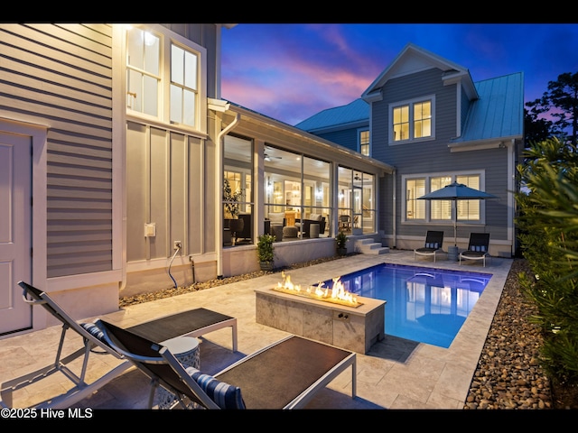 1012 Midnight Channel Rd, Wilmington, NC 28403 - pool at dusk with a fire pit, a patio, a sunroom, and an outdoor pool