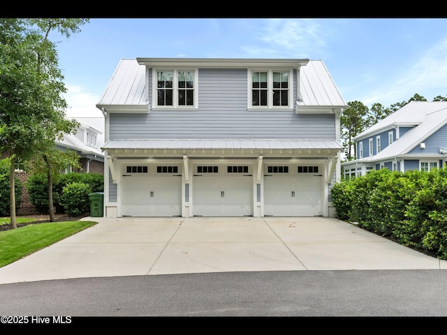 1012 Midnight Channel Rd, Wilmington, NC 28403 - view of front facade with an attached garage, metal roof, concrete driveway, and a standing seam roof