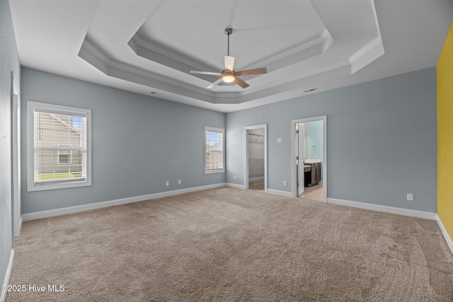 1006 Kingfish Way, New Bern, NC 28562 - unfurnished bedroom featuring a tray ceiling, carpet, baseboards, crown molding, and a walk in closet