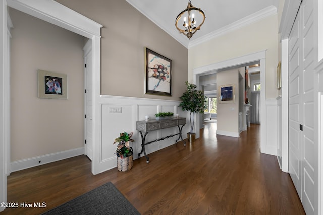 2570 Sugar Maple Ct, Southport, NC 28461 - entryway with crown molding, a chandelier, dark wood-type flooring, a decorative wall, and a wainscoted wall