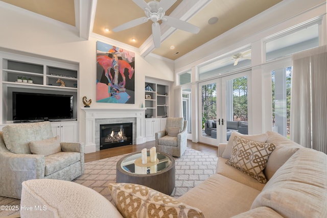 2570 Sugar Maple Ct, Southport, NC 28461 - living area featuring built in features, a ceiling fan, wood finished floors, a glass covered fireplace, and beam ceiling