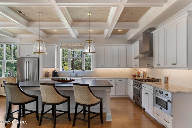 2570 Sugar Maple Ct, Southport, NC 28461 - kitchen featuring wall chimney range hood, premium appliances, dark wood-style floors, coffered ceiling, and white cabinets