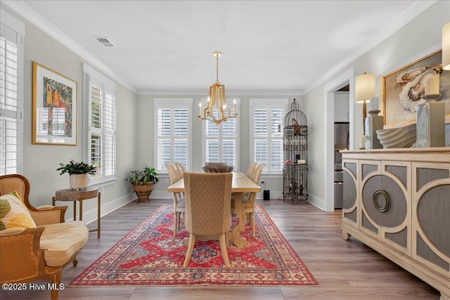 9294 Murphy Way SW, Calabash, NC 28467 - dining room featuring a chandelier, crown molding, healthy amount of natural light, light wood-style floors, and baseboards