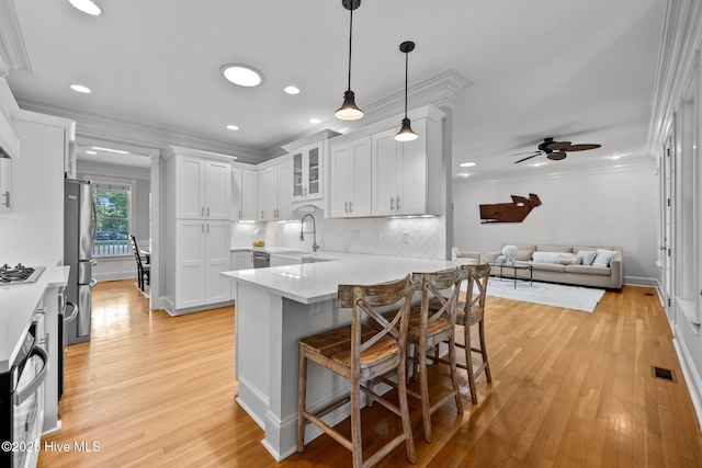 103 Low Country Ct, Hampstead, NC 28443 - kitchen featuring stainless steel appliances, a sink, a peninsula, open floor plan, and a breakfast bar
