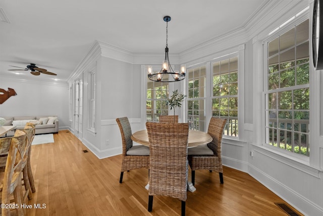 103 Low Country Ct, Hampstead, NC 28443 - dining area featuring a chandelier, light wood-type flooring, ornamental molding, a ceiling fan, and baseboards