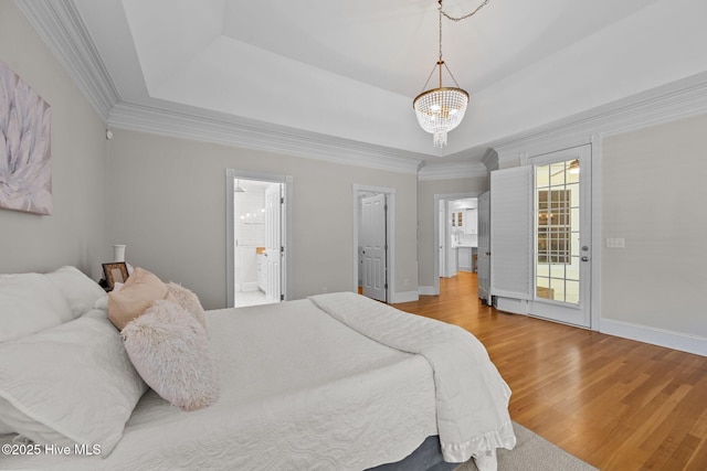103 Low Country Ct, Hampstead, NC 28443 - bedroom with a chandelier, wood finished floors, a tray ceiling, ornamental molding, and baseboards
