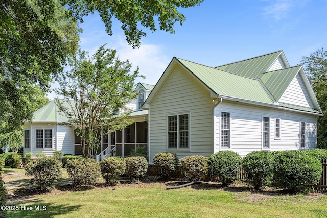 103 Low Country Ct, Hampstead, NC 28443 - view of front facade featuring a sunroom, a front yard, and metal roof