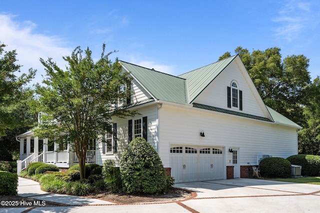 103 Low Country Ct, Hampstead, NC 28443 - view of side of home with concrete driveway, metal roof, a porch, an attached garage, and brick siding