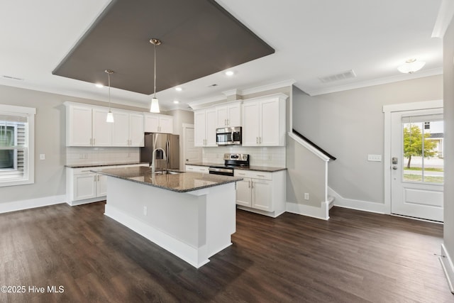749 Cypress Village Pl, Wilmington, NC 28412 - kitchen featuring stainless steel appliances, crown molding, dark wood-style flooring, backsplash, and an island with sink