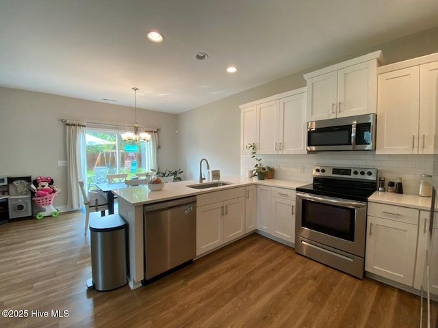 4224 Pegasus Pkwy, Leland, NC 28451 - kitchen with stainless steel appliances, a sink, a chandelier, a peninsula, and light countertops