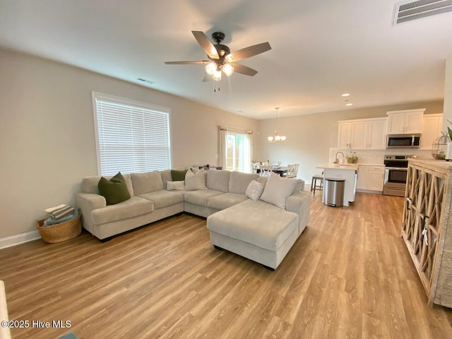 4224 Pegasus Pkwy, Leland, NC 28451 - living room featuring a ceiling fan, light wood-style flooring, baseboards, a chandelier, and recessed lighting