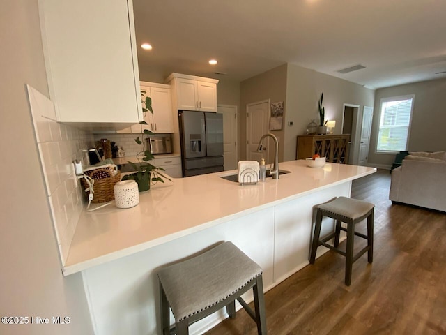 4224 Pegasus Pkwy, Leland, NC 28451 - kitchen featuring stainless steel refrigerator with ice dispenser, a peninsula, tasteful backsplash, open floor plan, and white cabinets