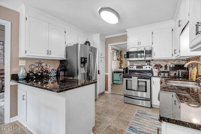208 N Woodridge Dr, Pikeville, NC 27863 - kitchen with appliances with stainless steel finishes, a sink, a peninsula, white cabinets, and crown molding