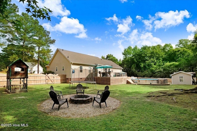 208 N Woodridge Dr, Pikeville, NC 27863 - view of yard featuring a fire pit, an outdoor pool, a trampoline, and a deck