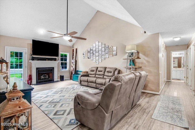 208 N Woodridge Dr, Pikeville, NC 27863 - living area with a ceiling fan, high vaulted ceiling, light wood-style floors, healthy amount of natural light, and baseboards