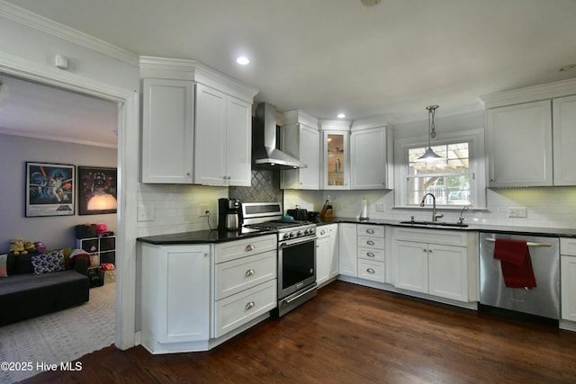 114 Lansdowne Rd, Wilmington, NC 28409 - kitchen featuring appliances with stainless steel finishes, wall chimney exhaust hood, a sink, dark countertops, and backsplash