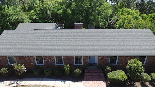 114 Lansdowne Rd, Wilmington, NC 28409 - view of front of house featuring a shingled roof, a chimney, and brick siding