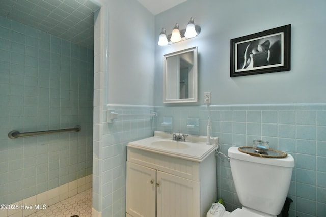 114 Lansdowne Rd, Wilmington, NC 28409 - bathroom featuring a stall shower, vanity, wainscoting, toilet, and tile walls