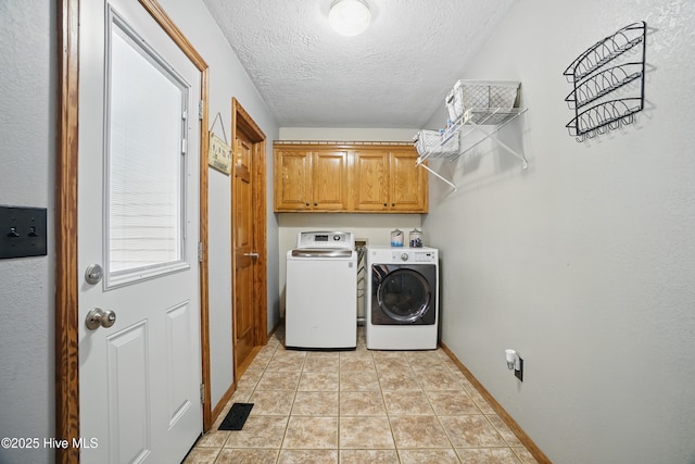 145 N Point Blvd, Moyock, NC 27958 - laundry area featuring cabinet space, washing machine and dryer, a textured ceiling, and baseboards
