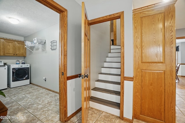 145 N Point Blvd, Moyock, NC 27958 - laundry room featuring cabinet space, washing machine and clothes dryer, light tile patterned floors, a textured ceiling, and baseboards