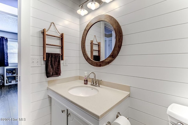 4838 Stillwell Rd, Wilmington, NC 28412 - bathroom with wood walls, vanity, toilet, and wood finished floors