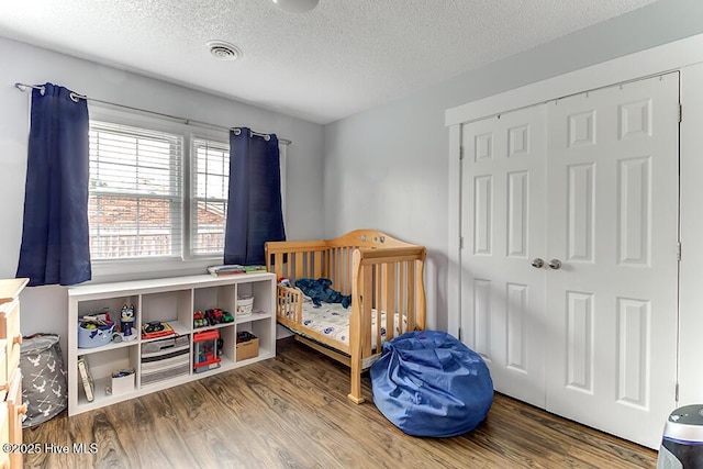 4838 Stillwell Rd, Wilmington, NC 28412 - bedroom featuring wood finished floors, a textured ceiling, and a closet
