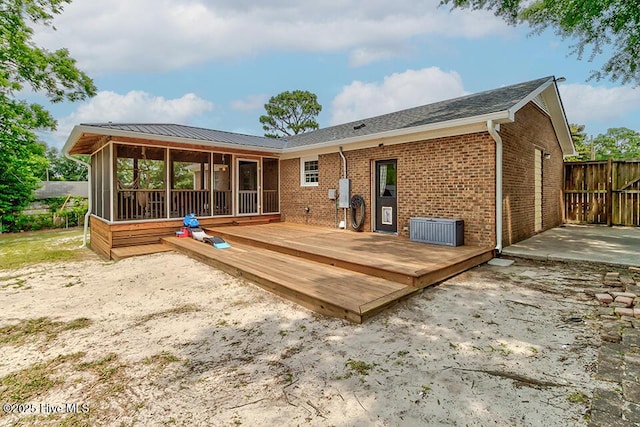 4838 Stillwell Rd, Wilmington, NC 28412 - rear view of house featuring a sunroom, brick siding, and a deck