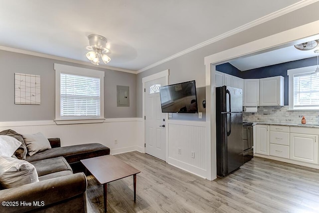 4838 Stillwell Rd, Wilmington, NC 28412 - living area featuring light wood-style flooring, a wainscoted wall, a ceiling fan, electric panel, and ornamental molding