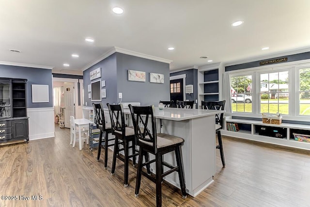4838 Stillwell Rd, Wilmington, NC 28412 - kitchen with ornamental molding, a breakfast bar, wood finished floors, recessed lighting, and wainscoting