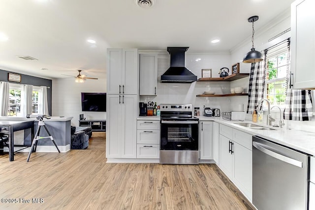 4838 Stillwell Rd, Wilmington, NC 28412 - kitchen with appliances with stainless steel finishes, wall chimney exhaust hood, a sink, light countertops, and light wood finished floors