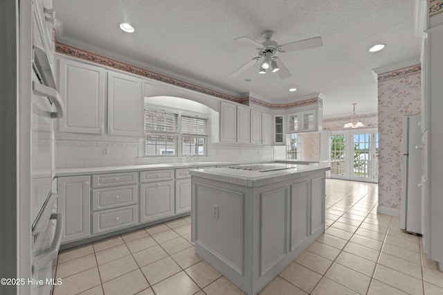 151 Pungo View Rd, Belhaven, NC 27810 - kitchen with ceiling fan, a center island, freestanding refrigerator, a chandelier, and tile counters