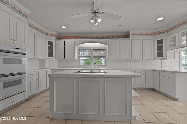151 Pungo View Rd, Belhaven, NC 27810 - kitchen featuring white double oven, plenty of natural light, a kitchen island, tile counters, and a textured ceiling