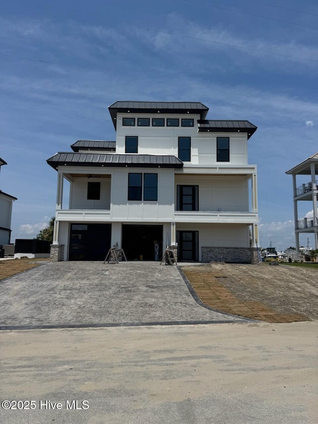 208 Radio Island Rd, Morehead City, NC 28557 - view of front of home with an attached garage, decorative driveway, metal roof, and a standing seam roof