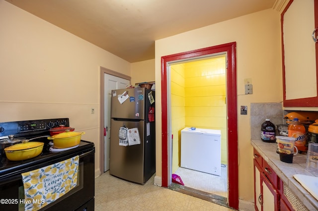 108 Stadium St SW, Wilson, NC 27893 - kitchen with freestanding refrigerator, black electric range oven, light floors, light countertops, and refrigerator