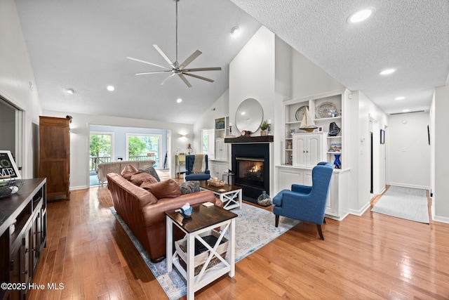 112 Lakeview Ln, Washington, NC 27889 - living room featuring ceiling fan, light wood finished floors, a glass covered fireplace, built in shelves, and high vaulted ceiling