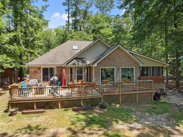 112 Lakeview Ln, Washington, NC 27889 - rear view of property with brick siding, a shingled roof, a wooden deck, and a sunroom