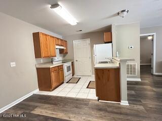 5610 Carolina Beach Rd Unit 6, Wilmington, NC 28412 - kitchen featuring white appliances, brown cabinets, light wood-style floors, and light countertops