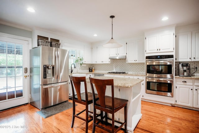 1103 Greenbriar Rd NW, Wilson, NC 27896 - kitchen featuring stainless steel appliances, under cabinet range hood, ornamental molding, white cabinets, and tasteful backsplash