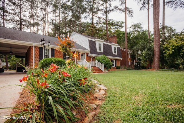 1103 Greenbriar Rd NW, Wilson, NC 27896 - view of front of home featuring brick siding, a chimney, a front lawn, roof with shingles, and driveway