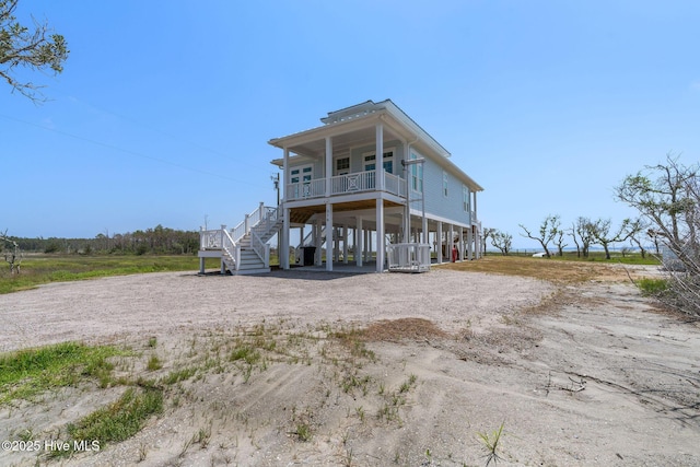 316 Bettie Path Rd, Beaufort, NC 28516 - rear view of property featuring stairway, covered porch, dirt driveway, and a carport