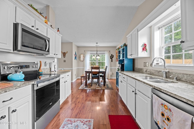 302 Fairmount Way, New Bern, NC 28562 - kitchen with appliances with stainless steel finishes, white cabinetry, wood finished floors, decorative light fixtures, and light stone counters