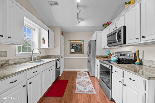 302 Fairmount Way, New Bern, NC 28562 - kitchen with appliances with stainless steel finishes, track lighting, white cabinets, light wood-style floors, and a textured ceiling