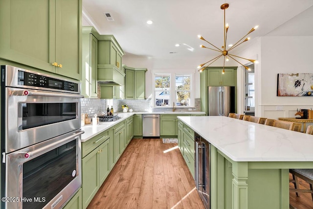 3810 River Park Way NE, Leland, NC 28451 - kitchen with green cabinets, stainless steel appliances, a chandelier, a kitchen island, and recessed lighting