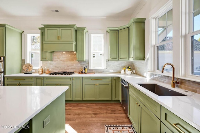3810 River Park Way NE, Leland, NC 28451 - kitchen featuring green cabinets, a sink, stainless steel appliances, backsplash, and wood finished floors