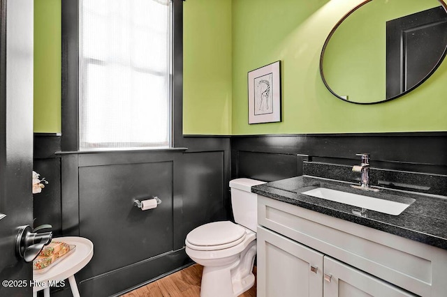 3810 River Park Way NE, Leland, NC 28451 - bathroom with toilet, wood finished floors, vanity, and wainscoting