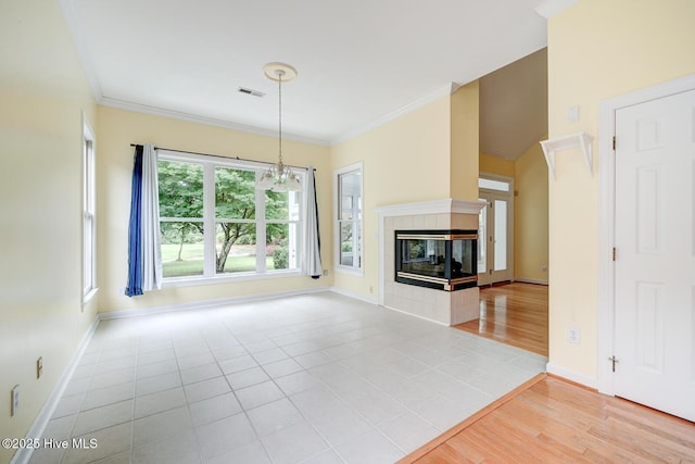 8500 Hammock Dunes Dr, Wilmington, NC 28411 - unfurnished living room featuring baseboards, ornamental molding, wood finished floors, a chandelier, and a tile fireplace