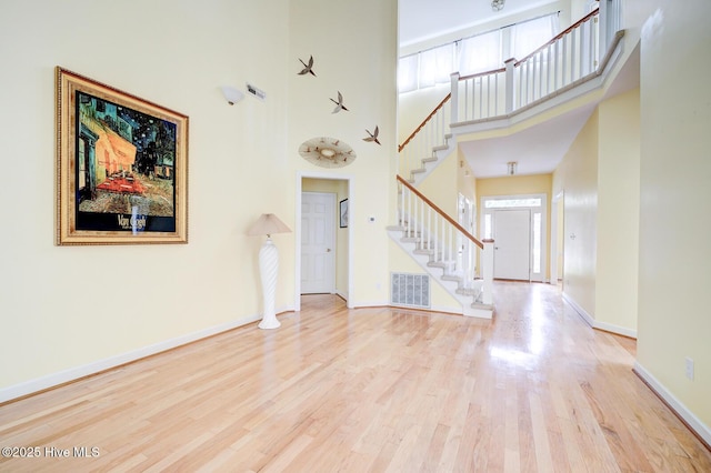 8500 Hammock Dunes Dr, Wilmington, NC 28411 - unfurnished living room with stairs, wood finished floors, a high ceiling, and baseboards