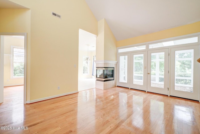 8500 Hammock Dunes Dr, Wilmington, NC 28411 - unfurnished living room with high vaulted ceiling, light wood-style floors, baseboards, and a fireplace