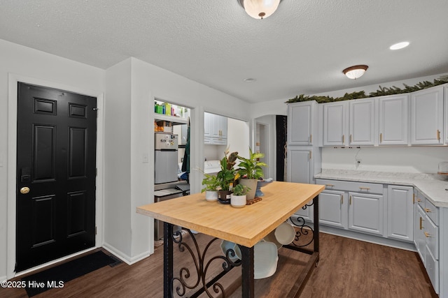 140 One Down St, Southern Pines, NC 28387 - kitchen featuring dark wood finished floors, a textured ceiling, freestanding refrigerator, white cabinets, and recessed lighting