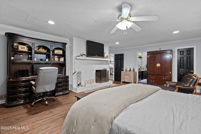 140 One Down St, Southern Pines, NC 28387 - bedroom with crown molding, wood finished floors, a fireplace, a desk, and recessed lighting